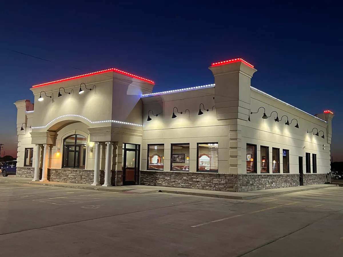 Chenoa Family Restaurant at dusk, its roofline lit in red and white