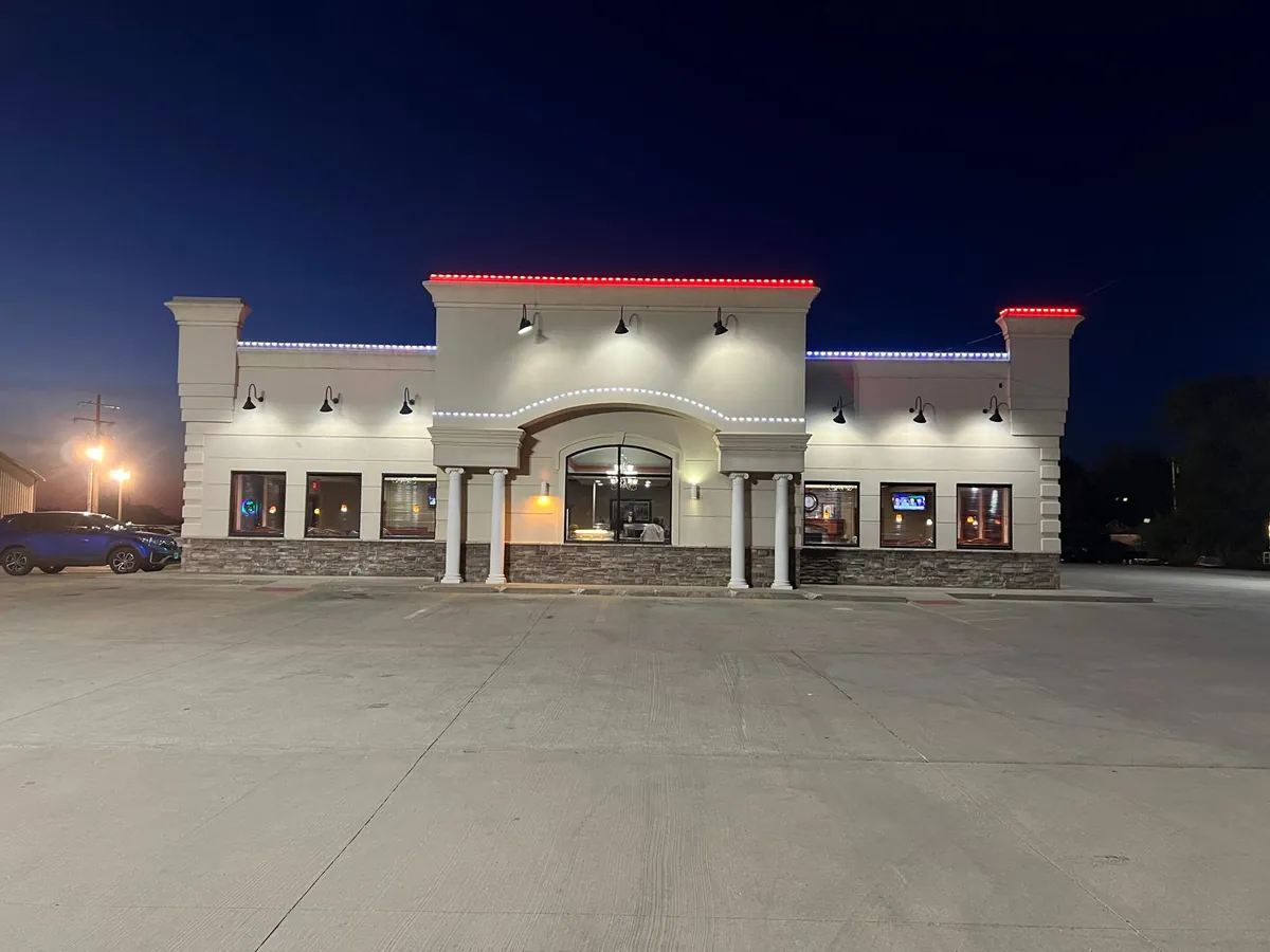 The front of Chenoa Family Restaurant and its columned entryway, lit at night