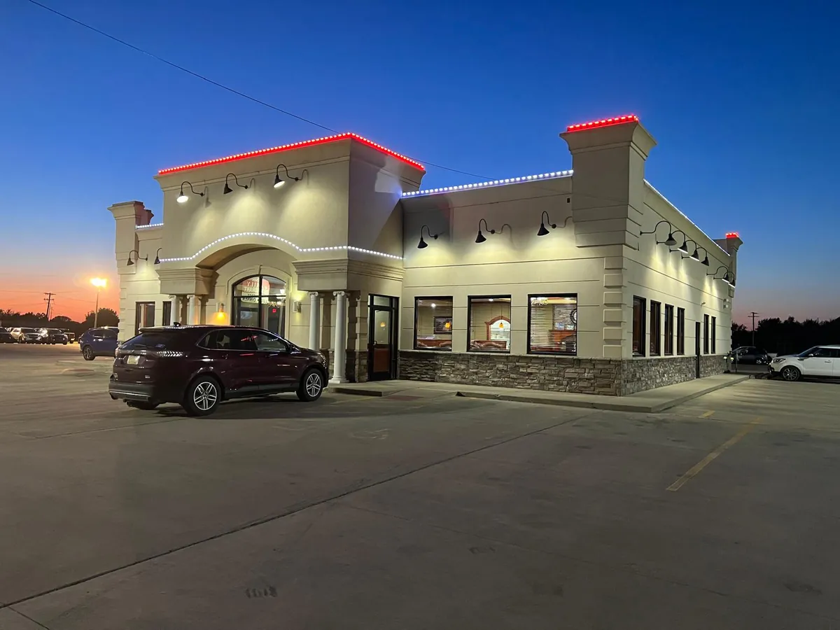The restaurant entrance and parking lot at sunset